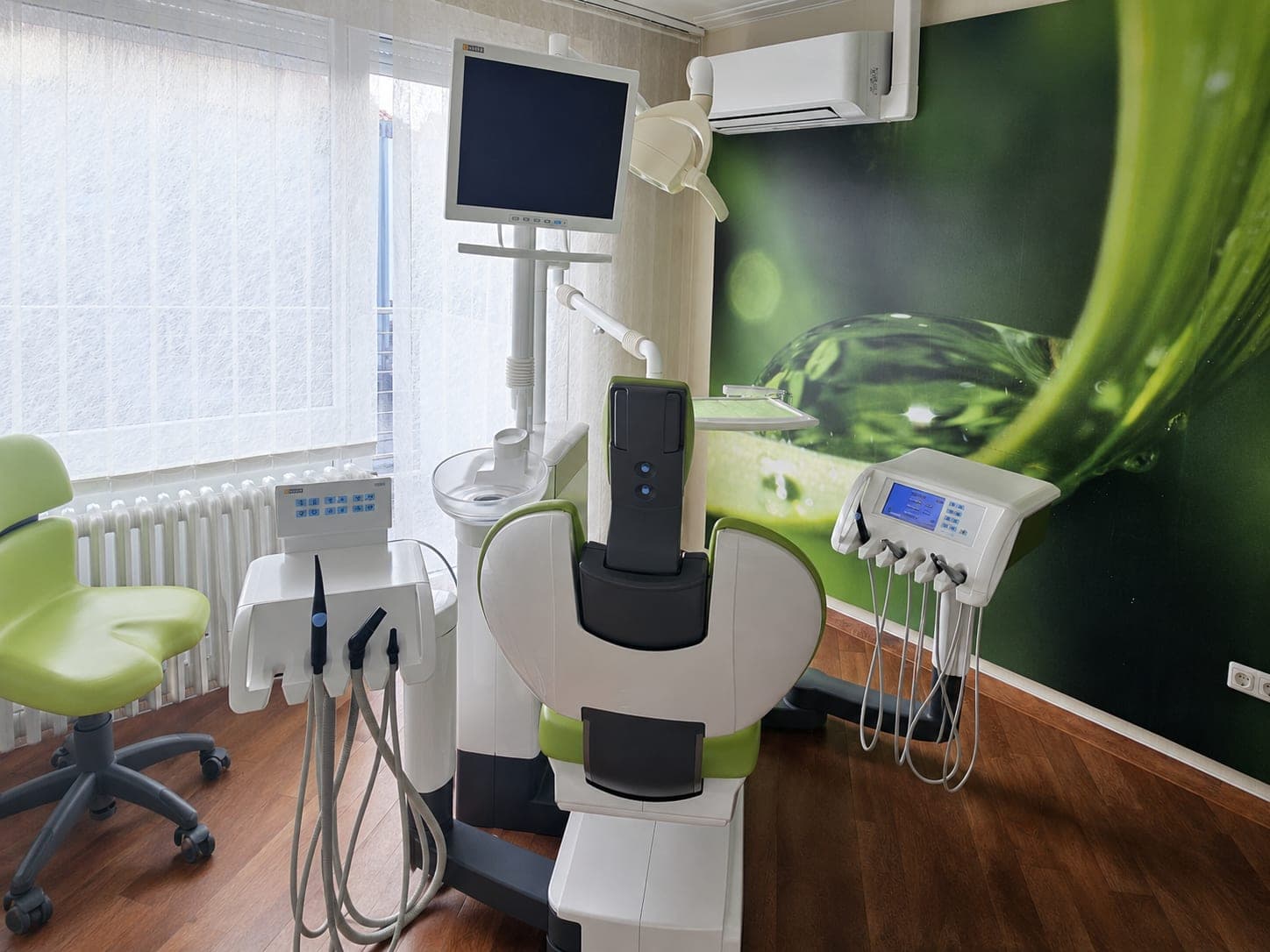 Ruhiges Behandlungszimmer mit grüner Wandgestaltung in der Zahnarztpraxis Mein Zahn Peine